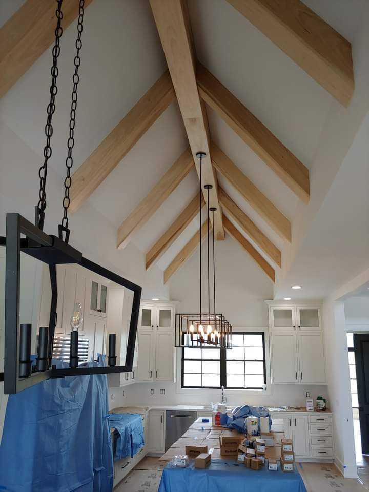 Natural wood beams across a vaulted kitchen ceiling during construction
